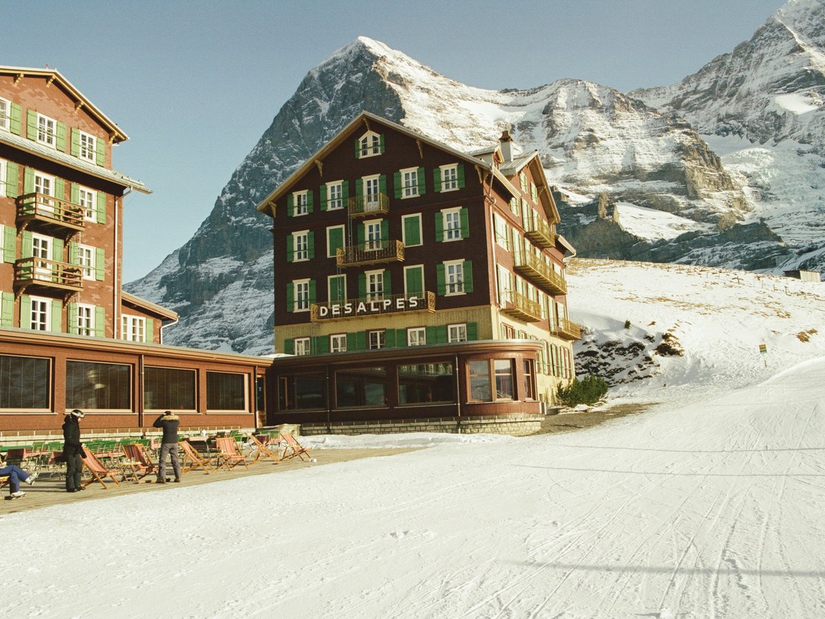 Alpine hotels beside a ski slope with towering snow-capped mountains