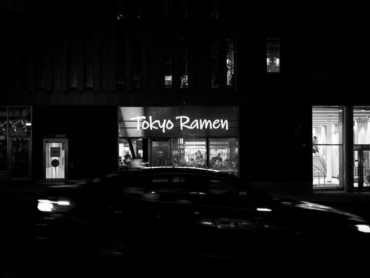 Tokyo ramen restaurant at night with car light streaks