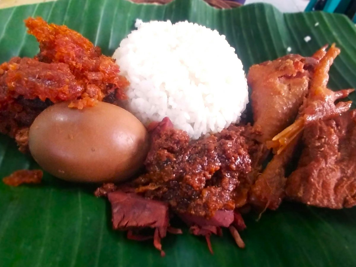 a close up of a plate of food on a banana leaf