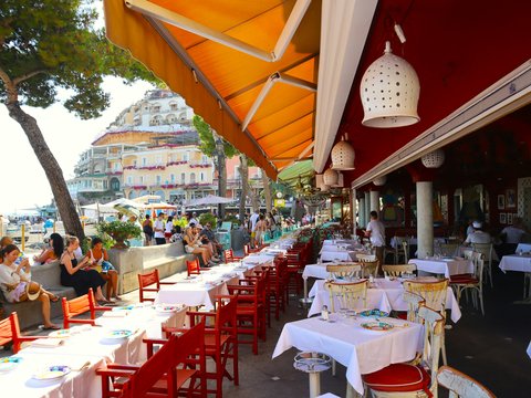a group of people sitting at tables under umbrellas