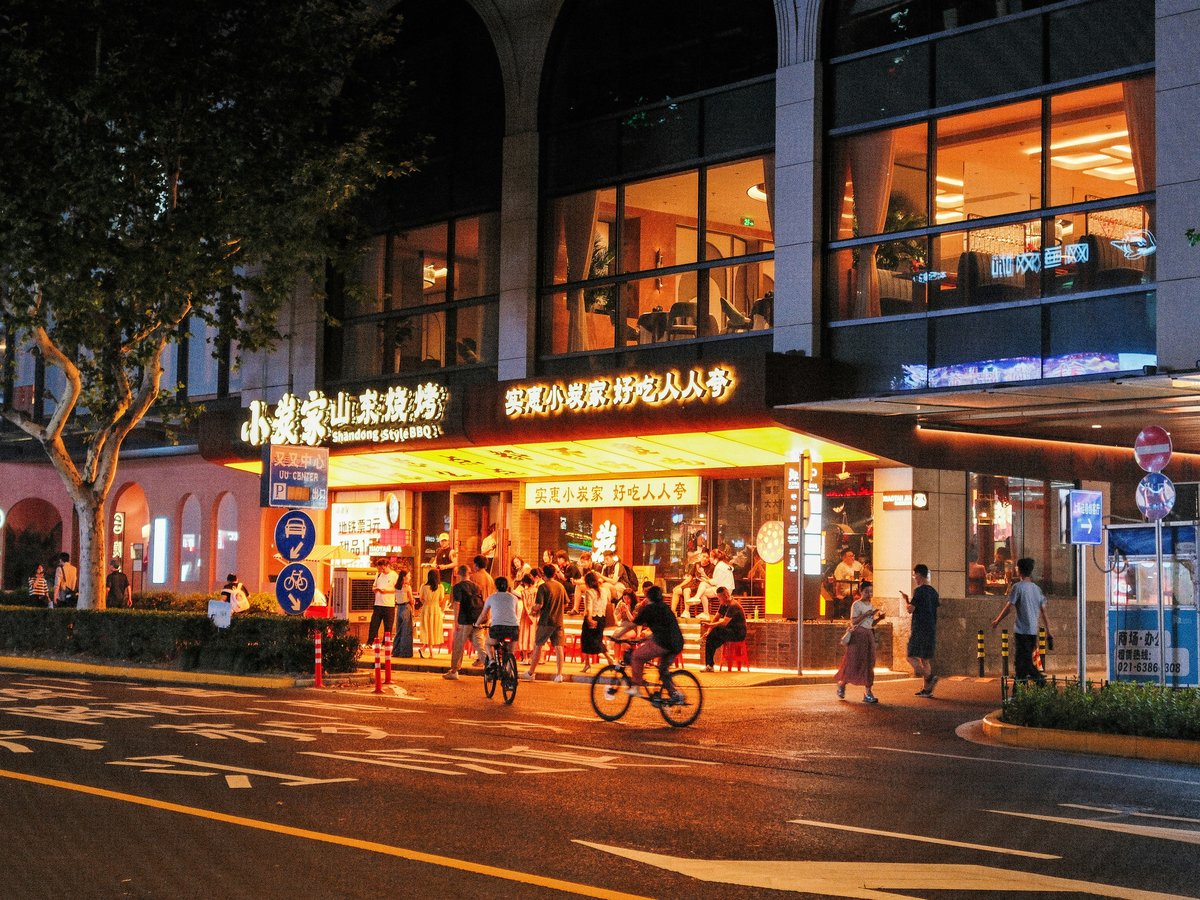 A group of people riding bikes down a street at night