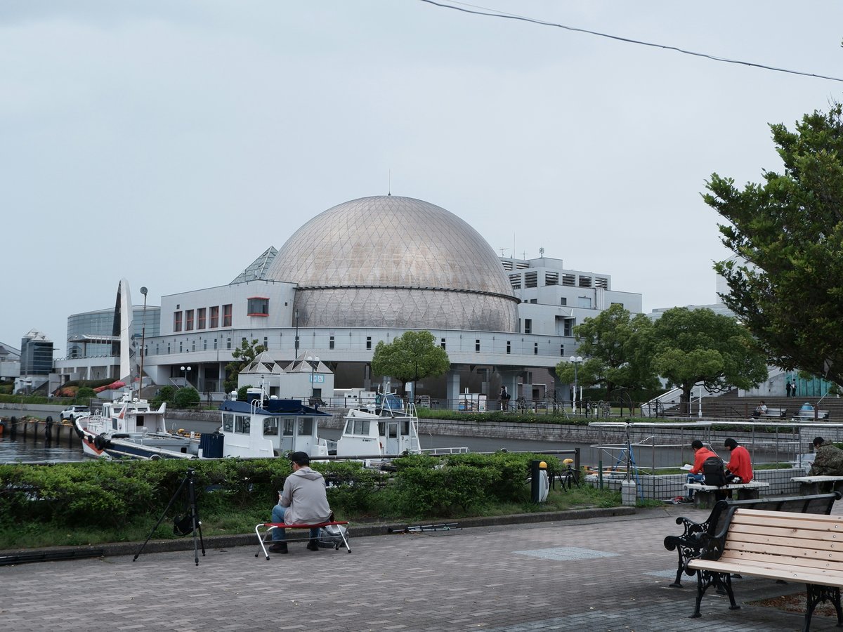 Modern building with dome near waterfront with people