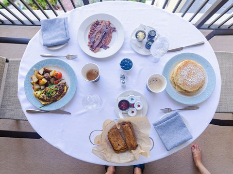 a table with plates of food and cups of coffee