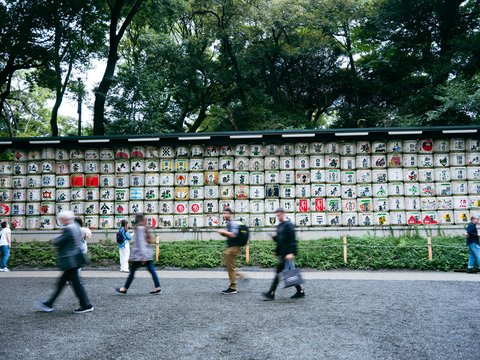 a group of people running in front of a building with signs on it