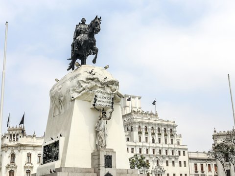 man riding horse statue near white concrete building during daytime