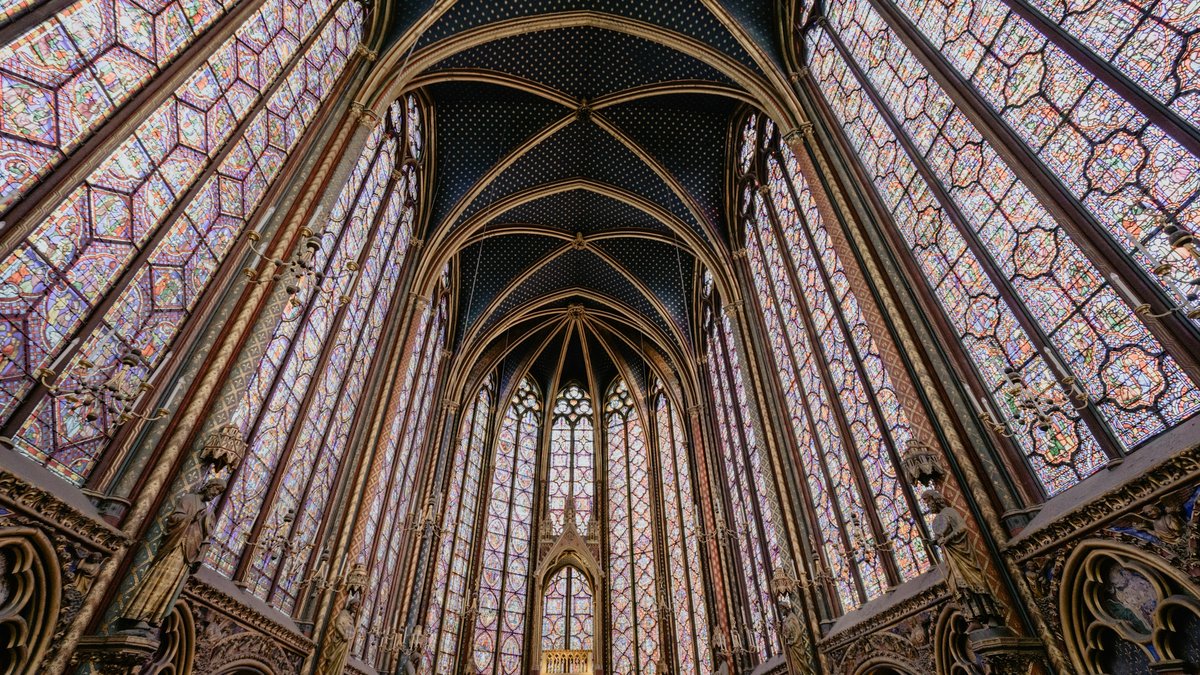Looking straight up into Sainte-Chapelle's rib-vaulted ceiling, the gothic arches framed by towering walls of ruby and sapphire stained glass