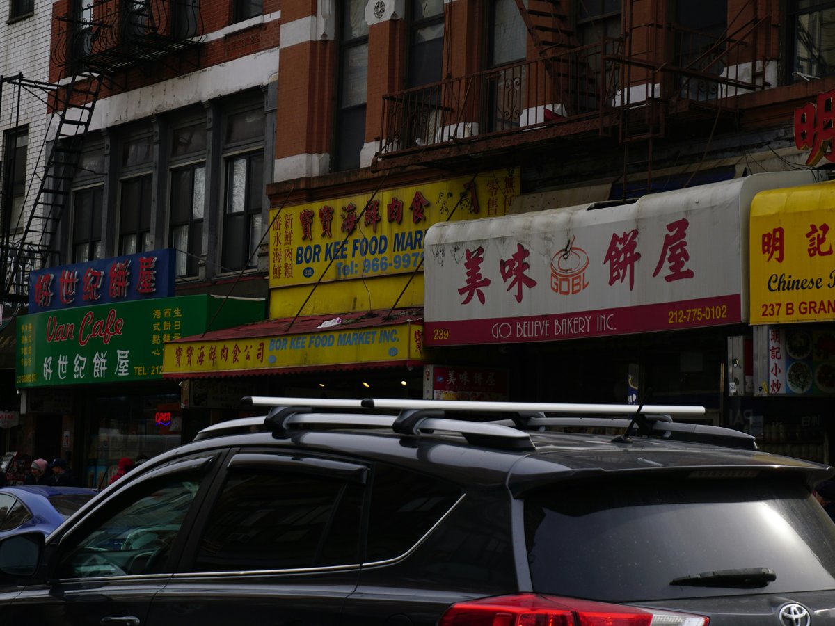 A street scene with shops and a car.