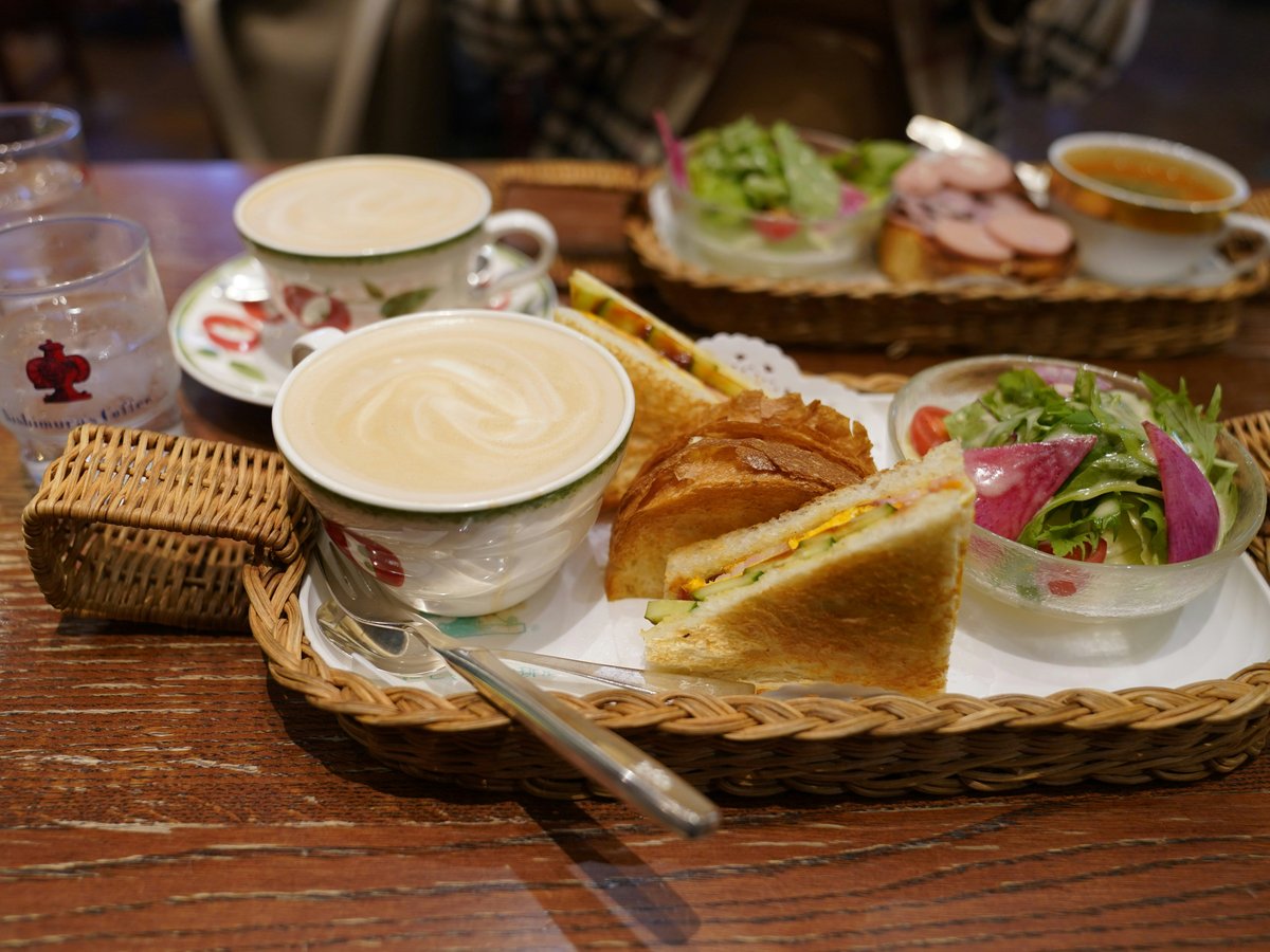 A wooden table topped with two baskets filled with food