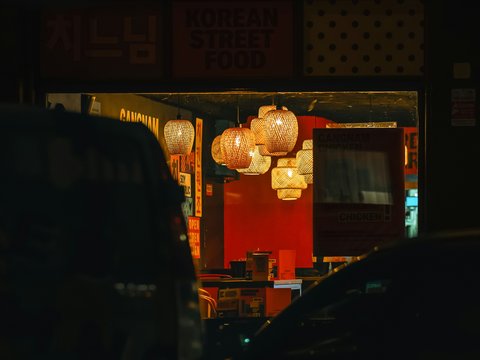 A car parked in front of a restaurant at night