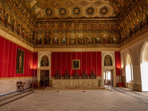 a large room with a red wall and a painting on the wall