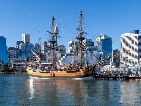 A tall ship in the water near a city