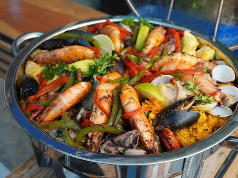 A large pan of seafood paella with shrimp and mussels