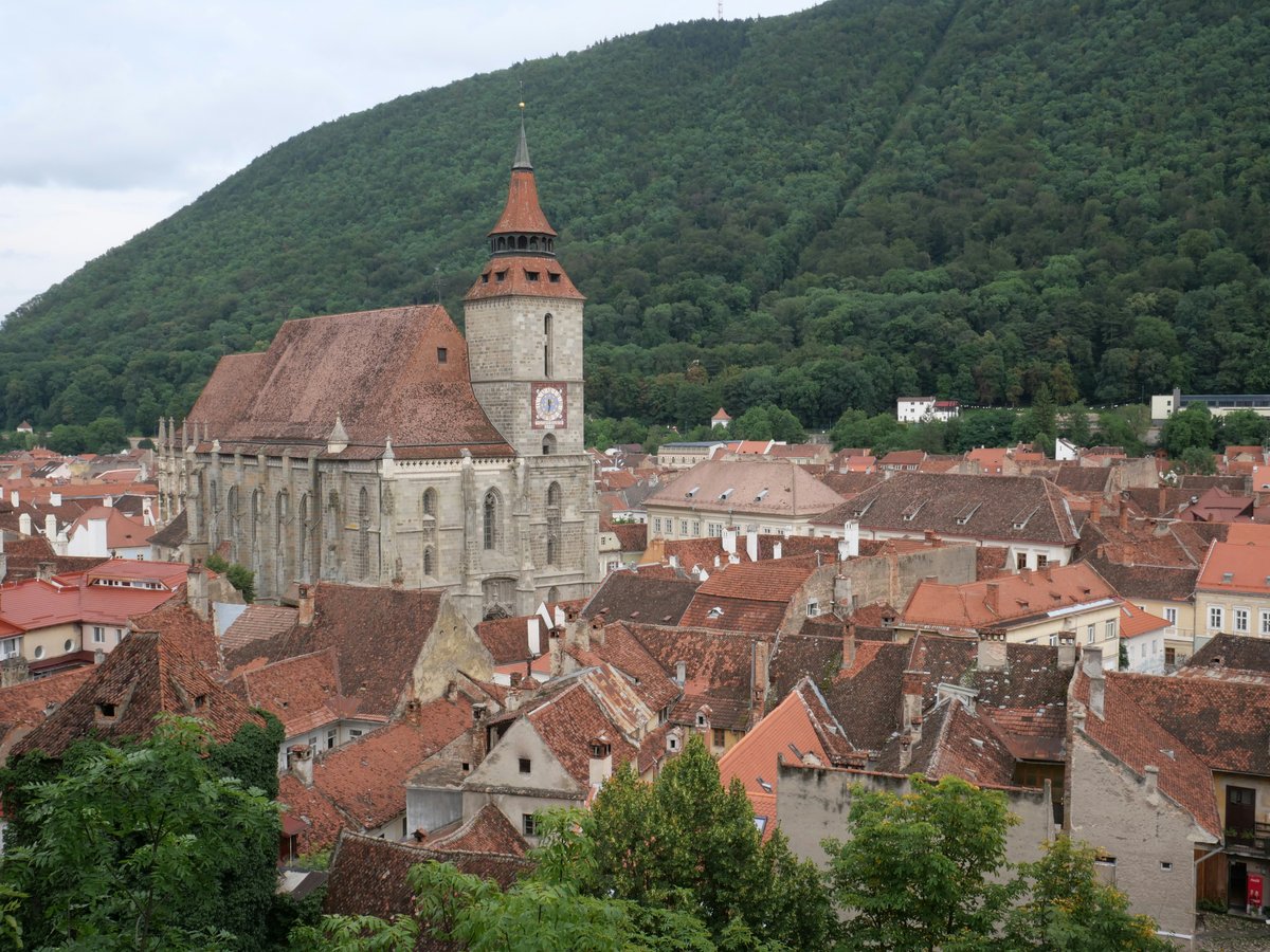 Medieval town with a large church and mountain background