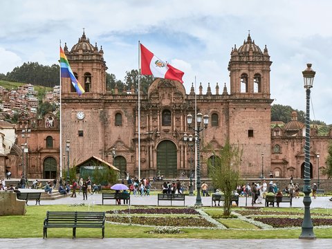 people walking near Cusco Cathedral in Peru under white and blue sky