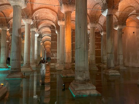 A person standing in a large room with columns