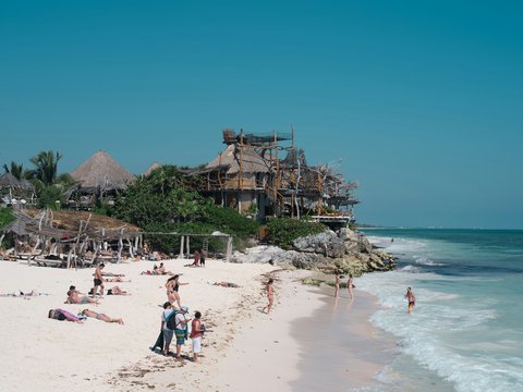 A group of people standing on top of a sandy beach