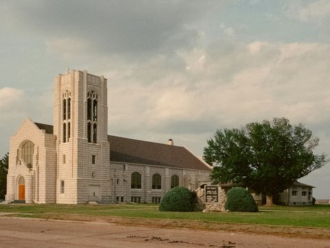 a large church with a tall steeple on a cloudy day