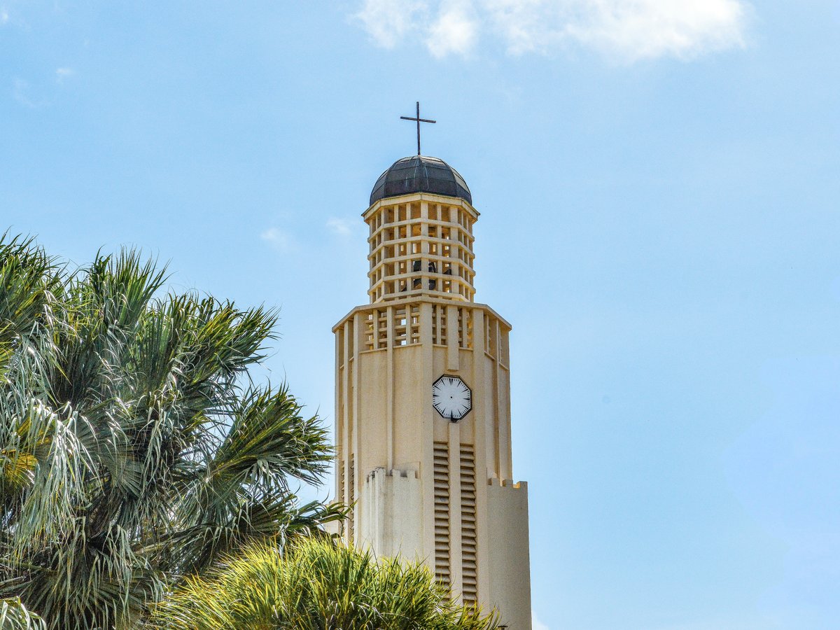 a tall clock tower with a cross on top