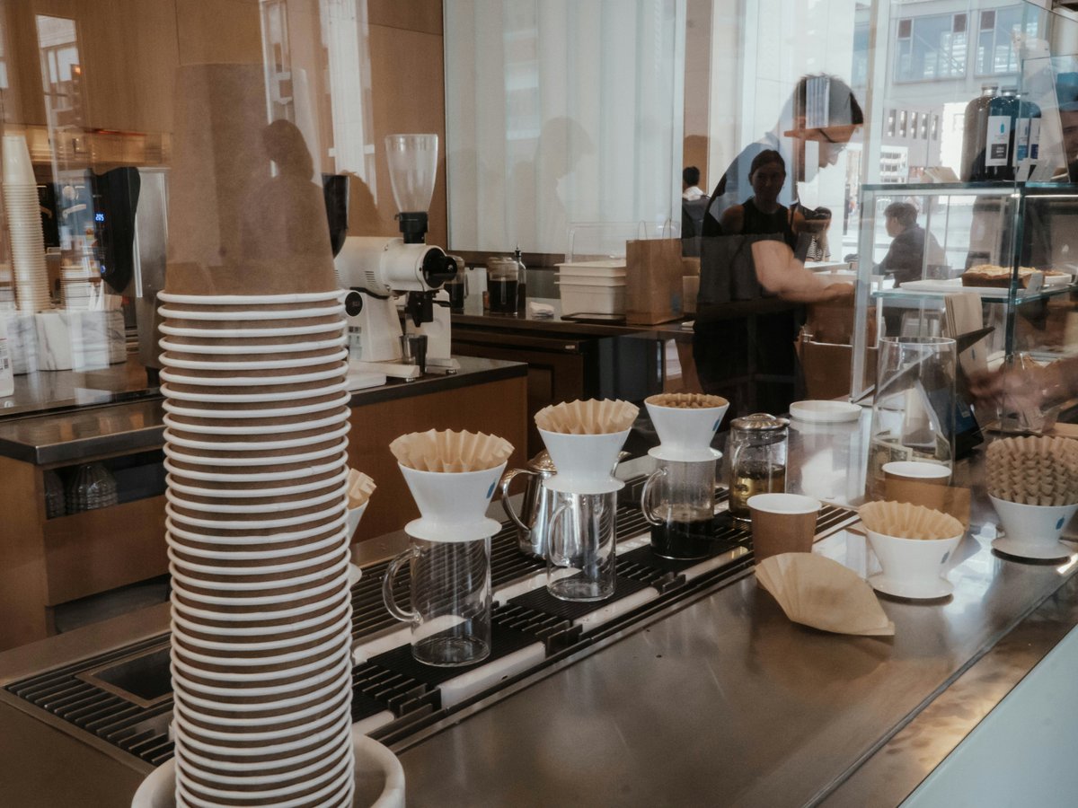 a coffee shop counter with coffee cups stacked on top of each other