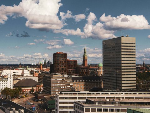 city buildings under white clouds and blue sky during daytime