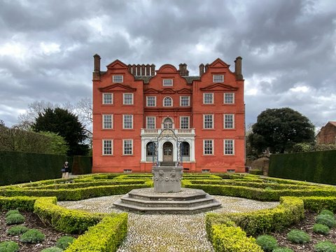 a large red building with a garden in front of it
