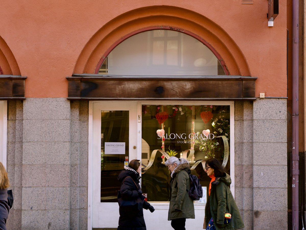 People are walking in front of a shop.
