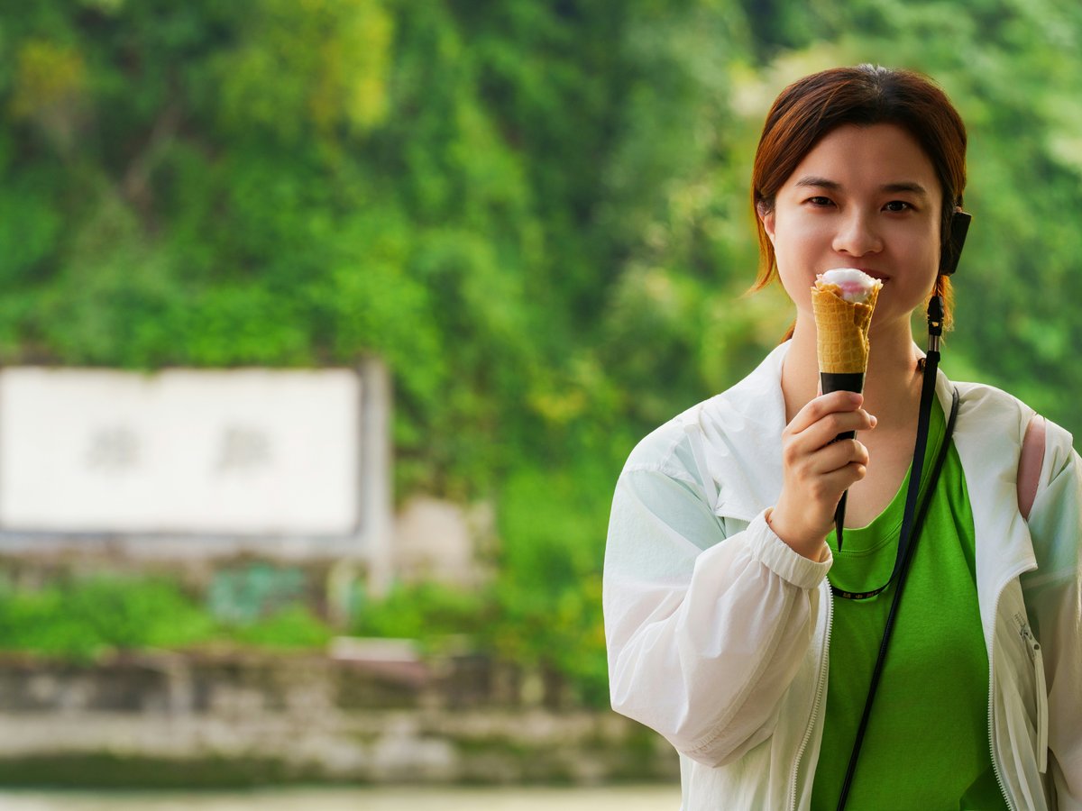 A young woman holding an ice cream cone and smiling
