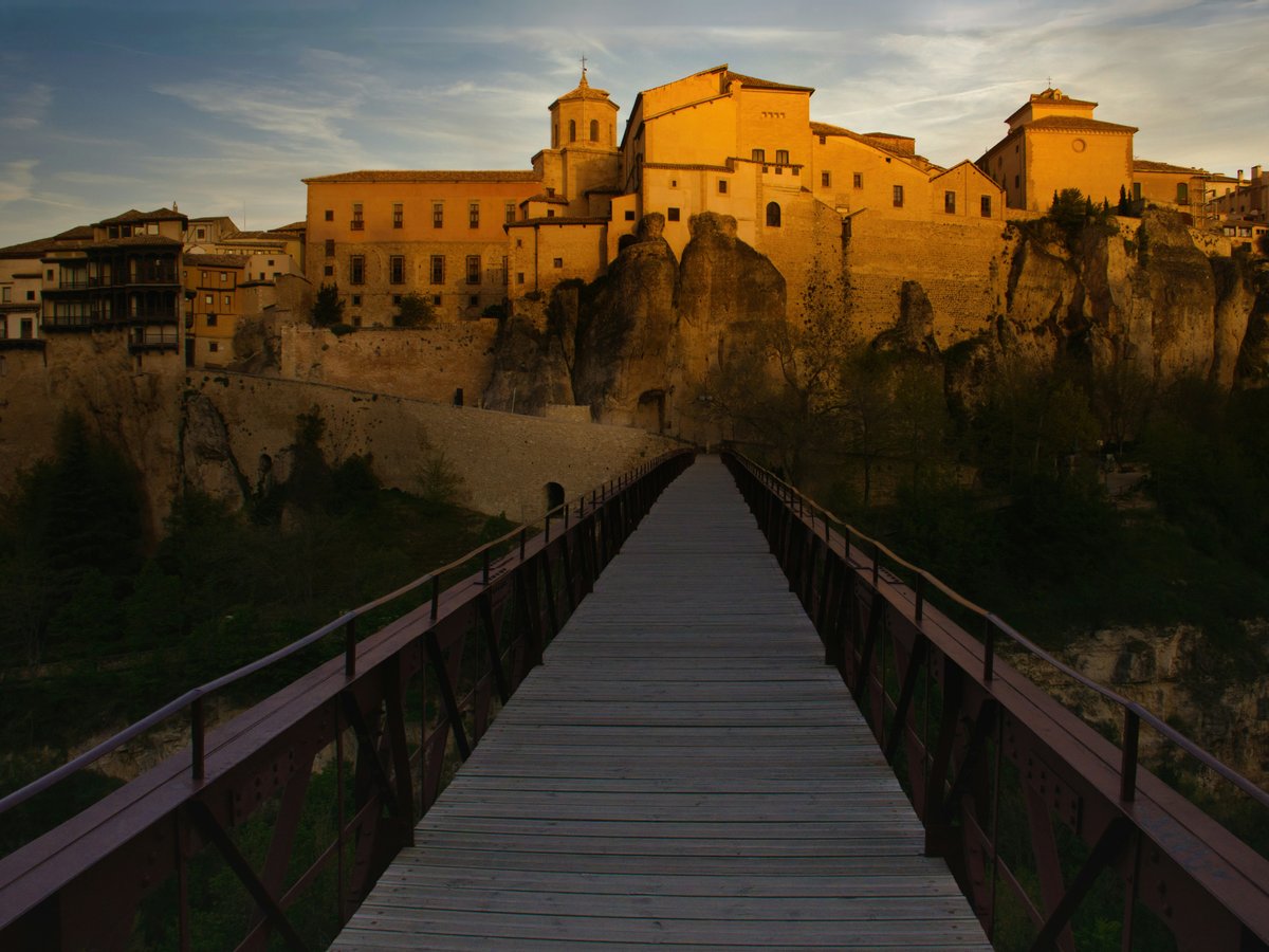 Bridge leading to a sunlit medieval city.