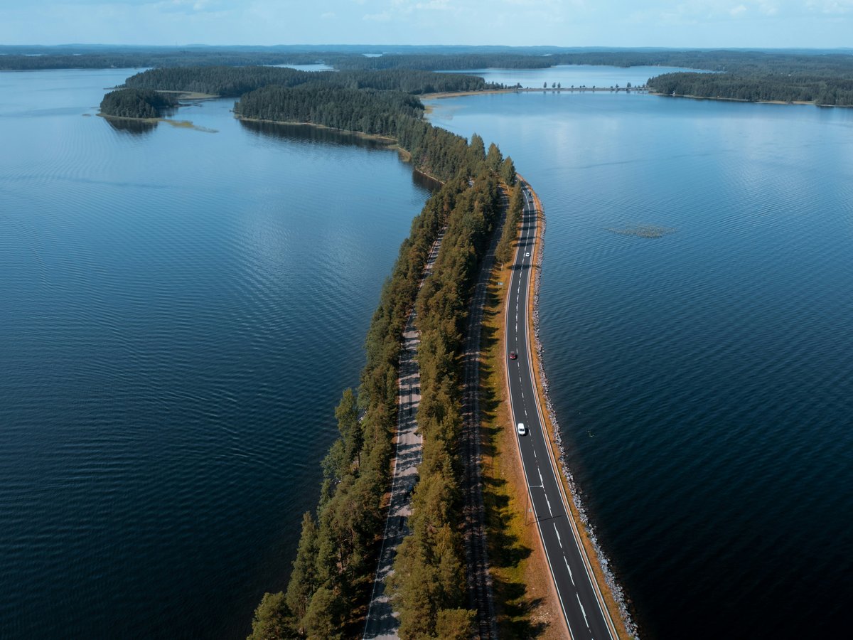 an aerial view of a highway near a body of water