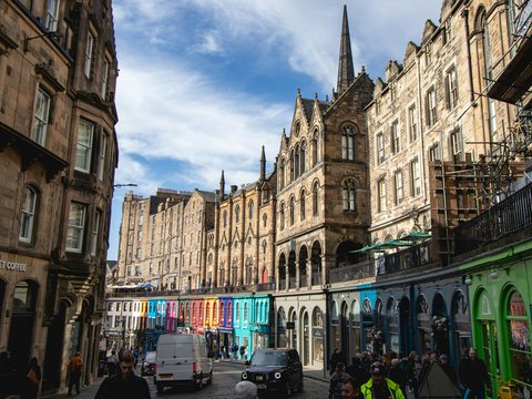 Historic buildings and colorful storefronts line the street.