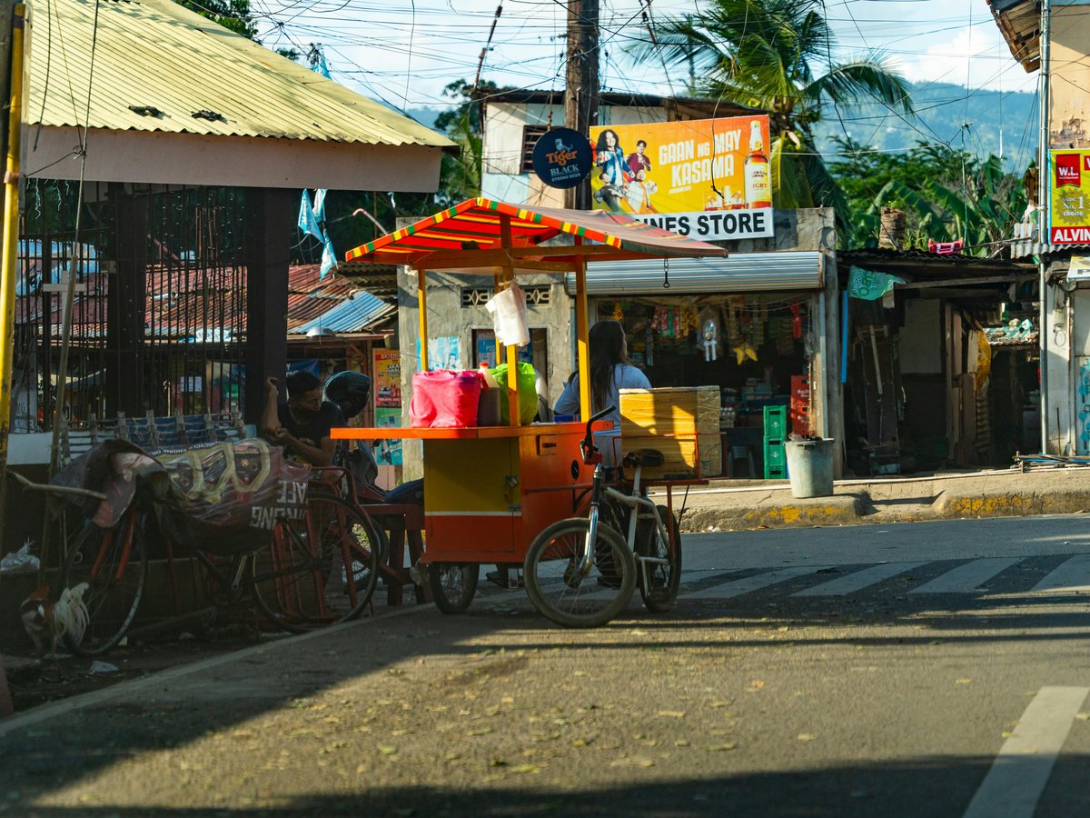 a street scene with a street vendor on the side of the road