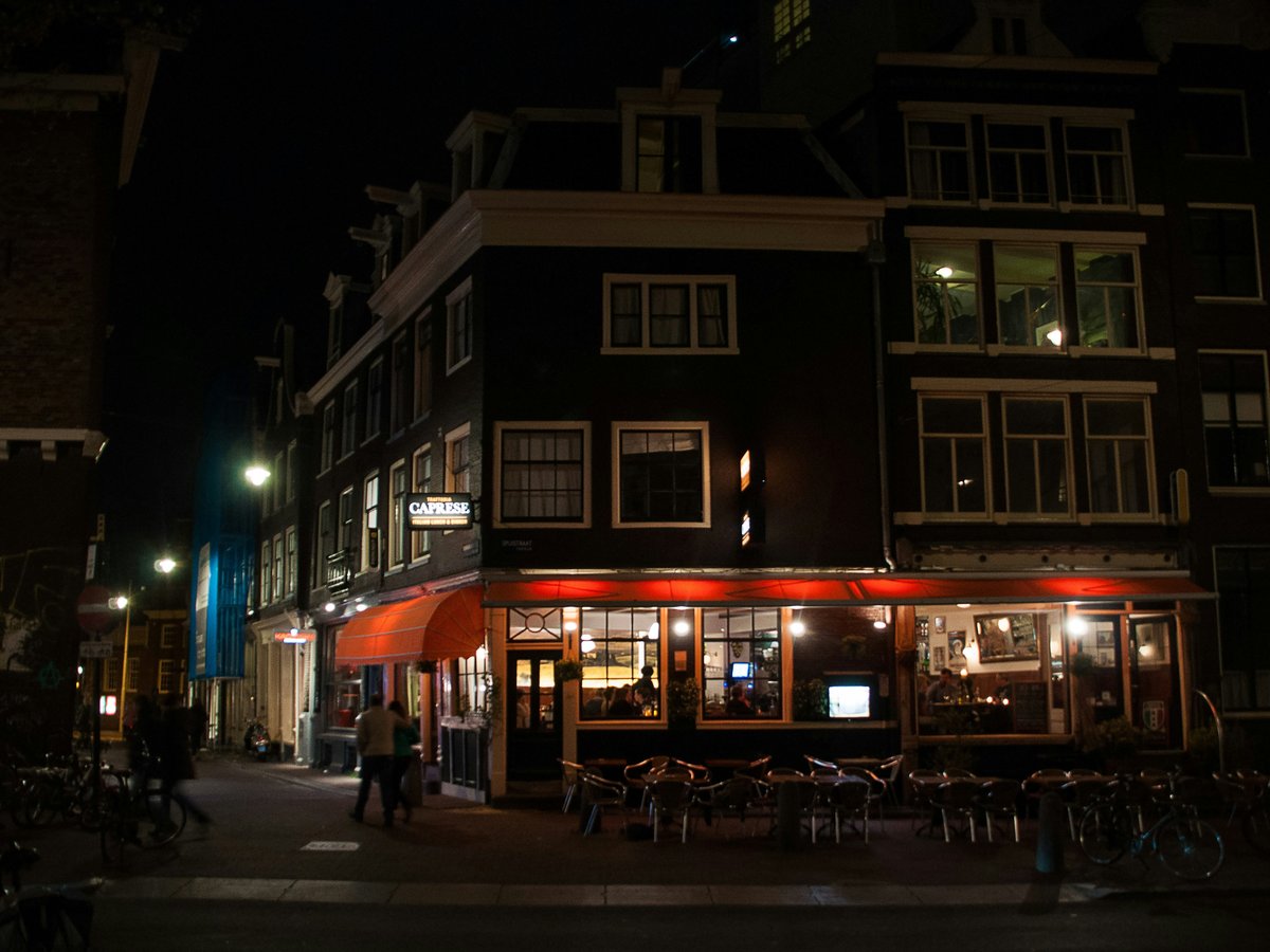 a dark city street at night with people walking by