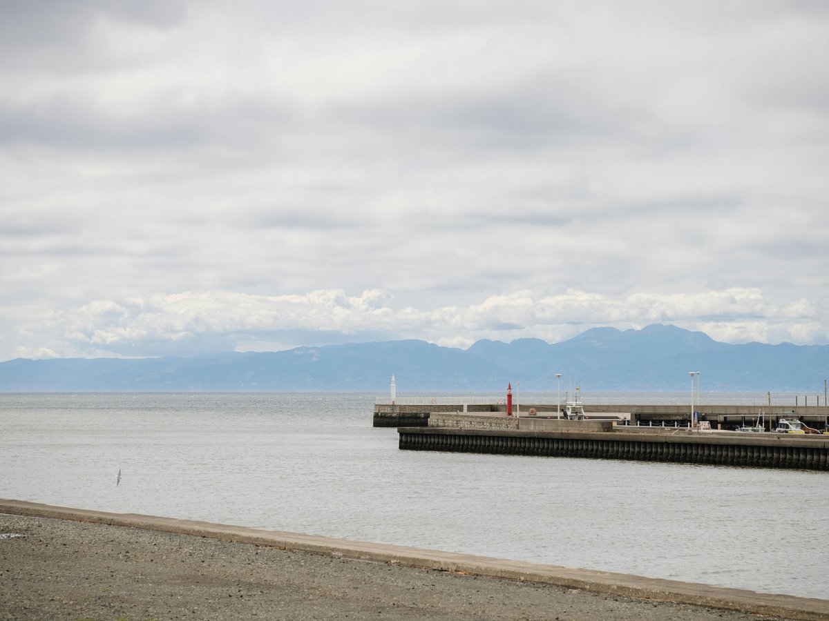 A harbor with a pier and mountains on the horizon