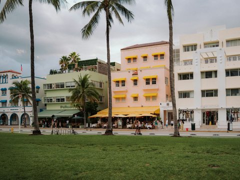 Colorful buildings and palm trees on a street.