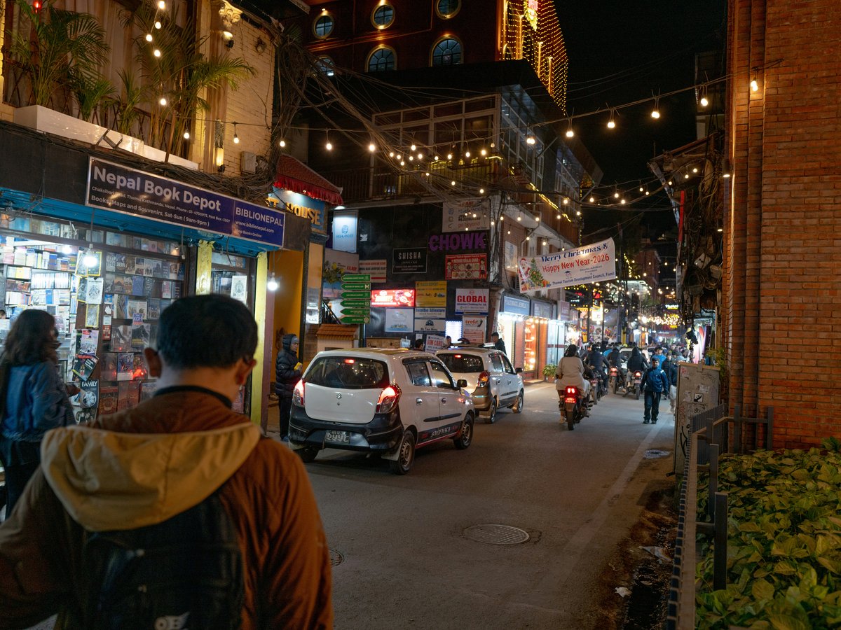 Street scene at night with shops and cars
