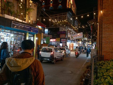 Street scene at night with shops and cars