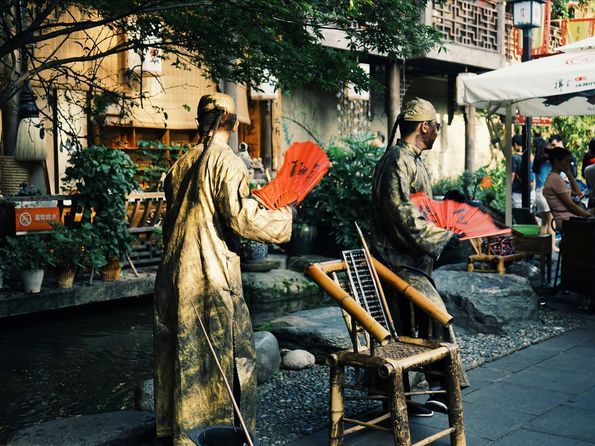 A man holding a red frisbee standing next to a chair