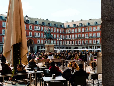 a group of people sitting at tables in a courtyard