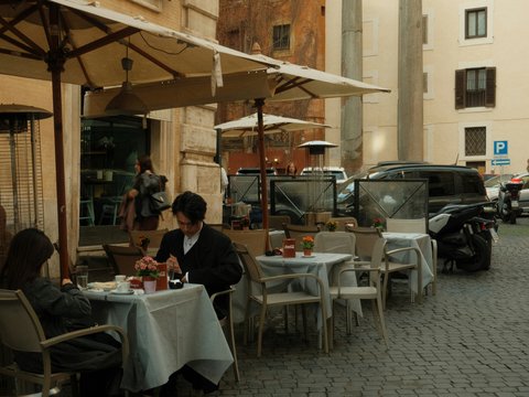 People are eating outside at an italian cafe.