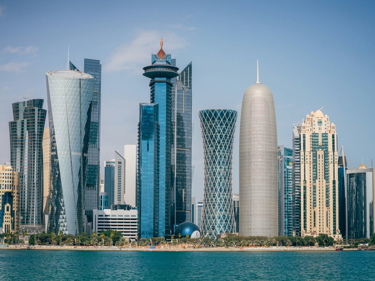 a group of tall buildings sitting next to a body of water