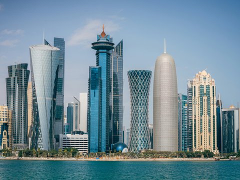 a group of tall buildings sitting next to a body of water
