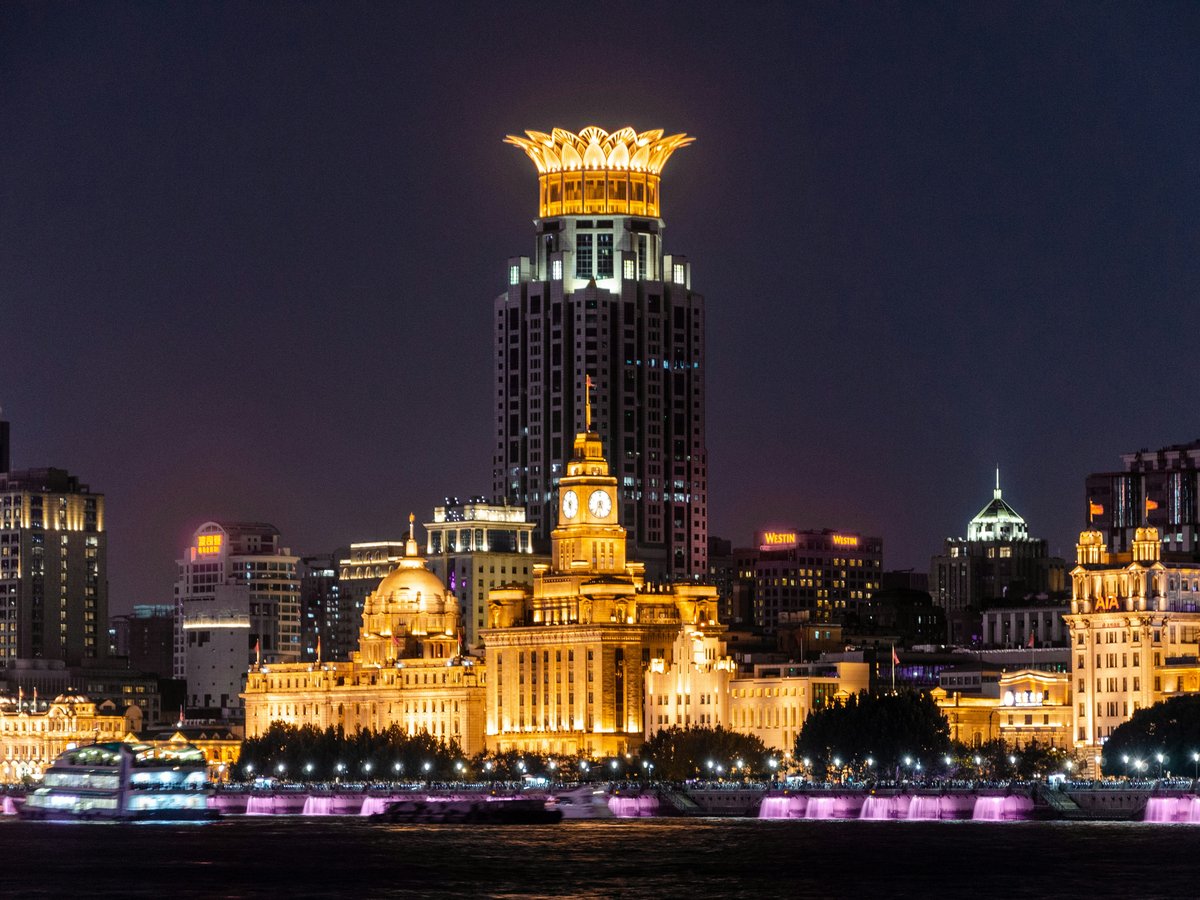 a city skyline at night with a lit up clock tower