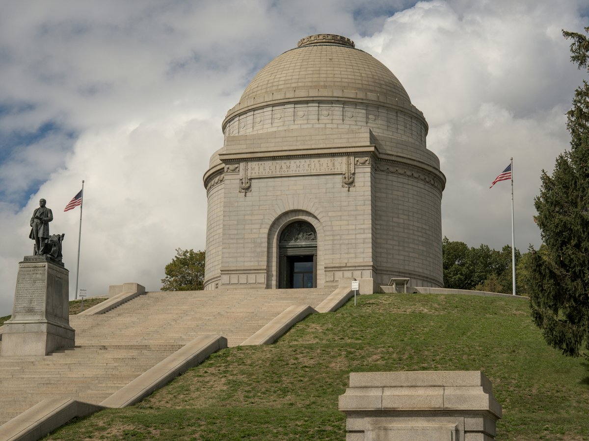 A monument building with stairs and flags