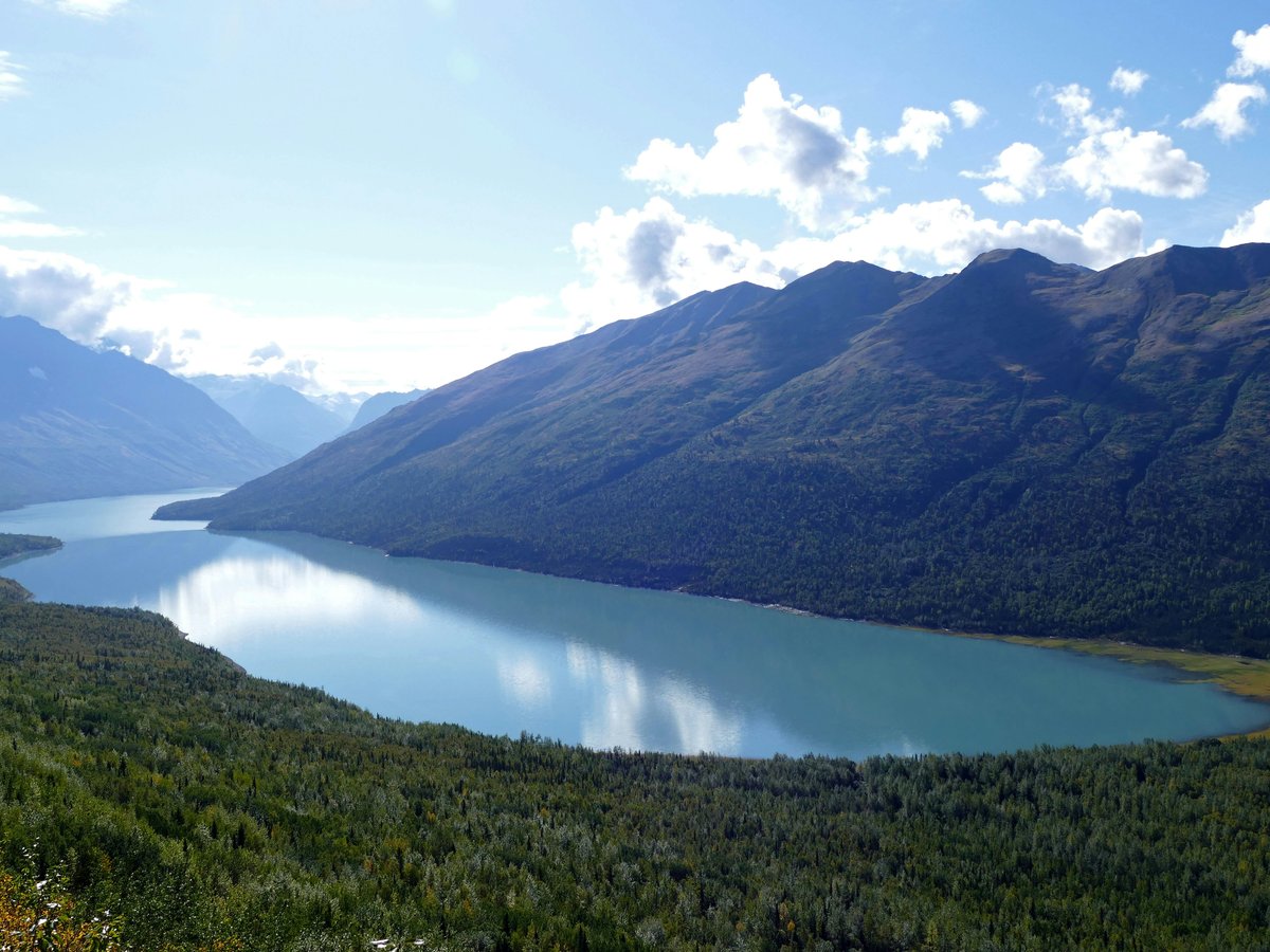 lake in the middle of mountains during daytime
