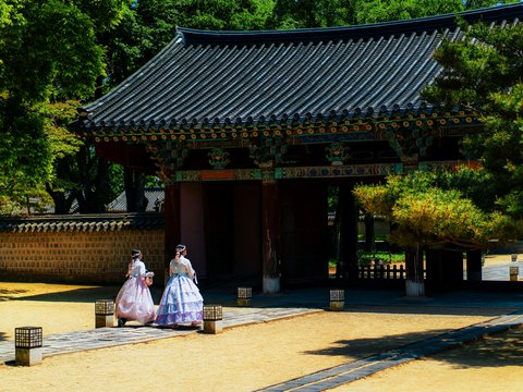 a couple of women walking down a street next to a building