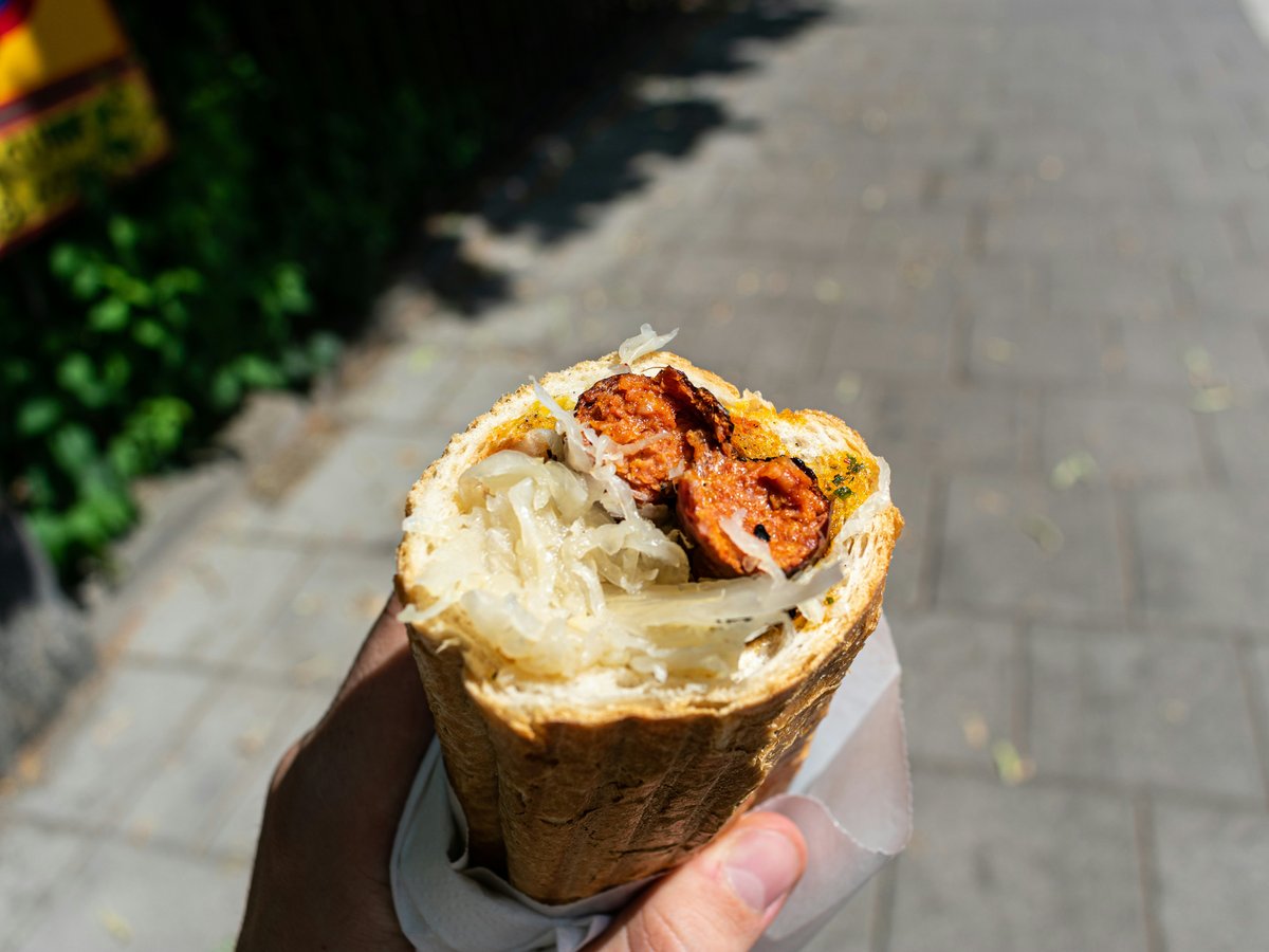 a person holding a sandwich in their hand