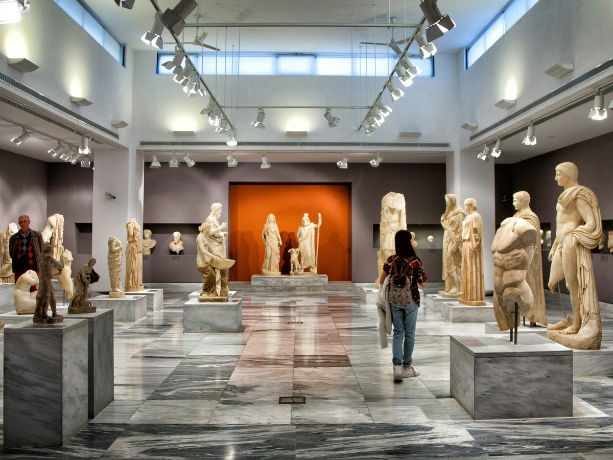 a woman standing in front of a bunch of statues
