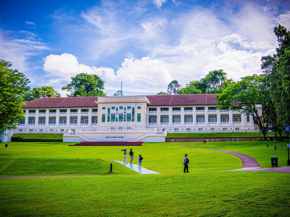 A large white building sitting on top of a lush green field