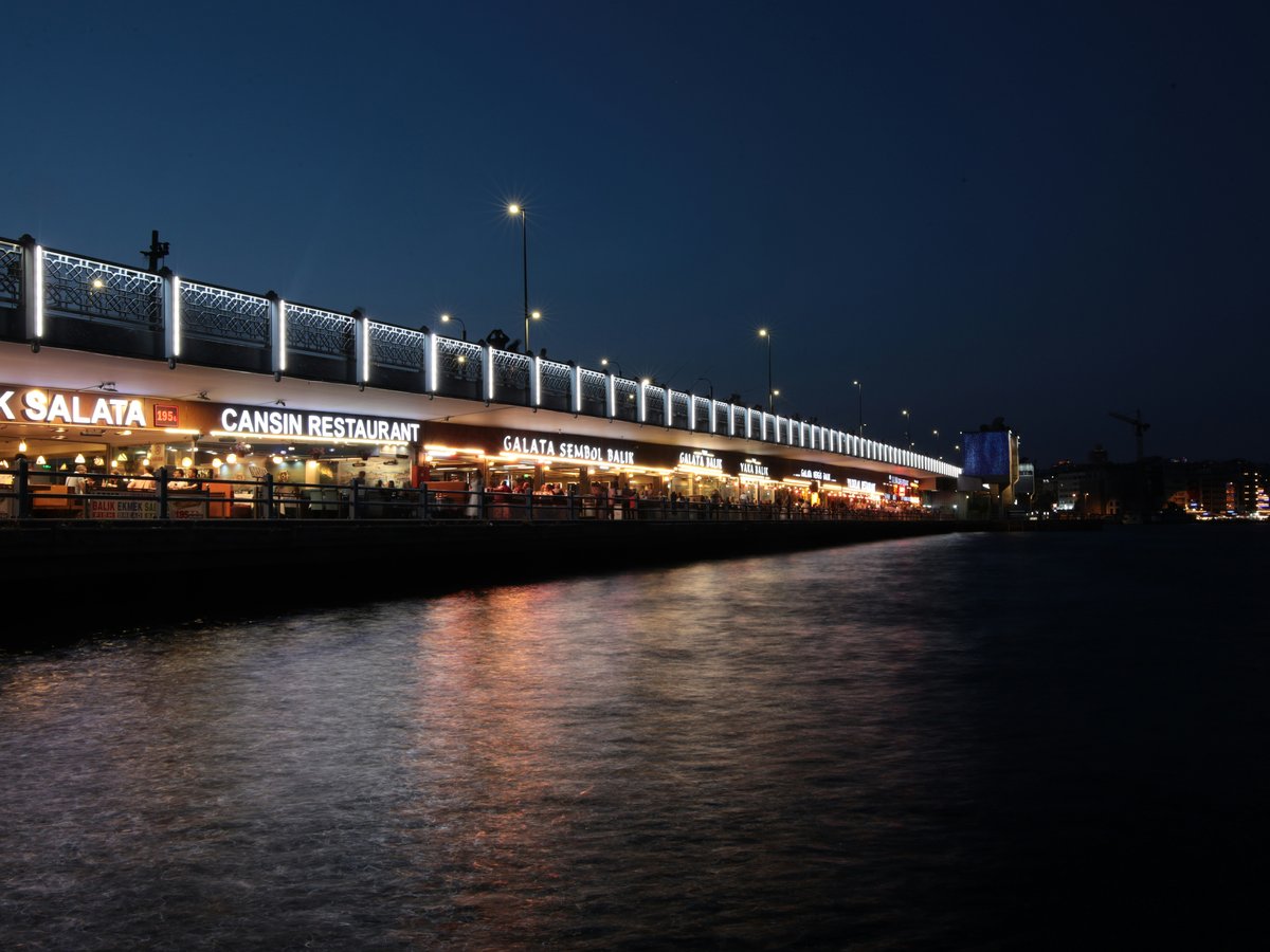 City bridge lights reflecting on water at night.