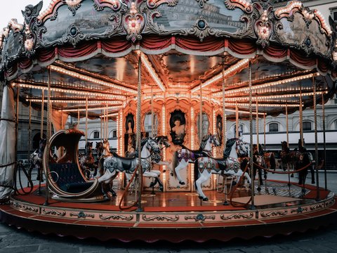 brown horse carousel with people riding